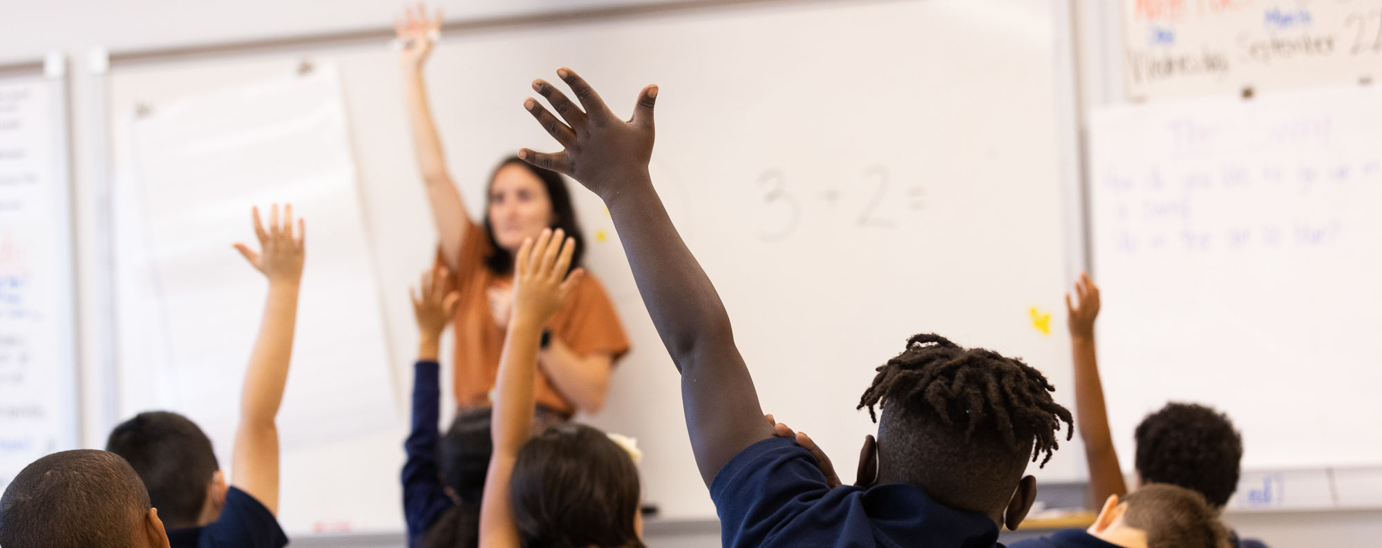 ACAR students raising their hands in class
